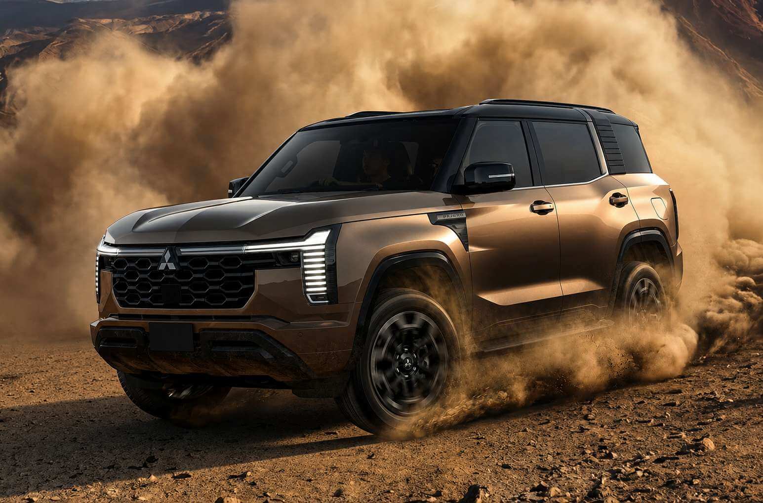 Mitsubishi Pajero 2027 em movimento sobre um terreno de cascalho e terra batida, visto de tres quartos dianteiro-lateral e levemente de baixo. A carroceria e marrom-acobreada com teto preto, linhas retas e caixas de roda quadradas em plastico escuro; as rodas escuras de raios grossos levantam uma grande nuvem de poeira alaranjada que cobre o fundo de montanhas aridas. O angulo evidencia a altura livre do solo de 23 centimetros, o para-choque dianteiro robusto e a grade hexagonal escura com o emblema de tres diamantes da Mitsubishi. A placa dianteira esta em branco.