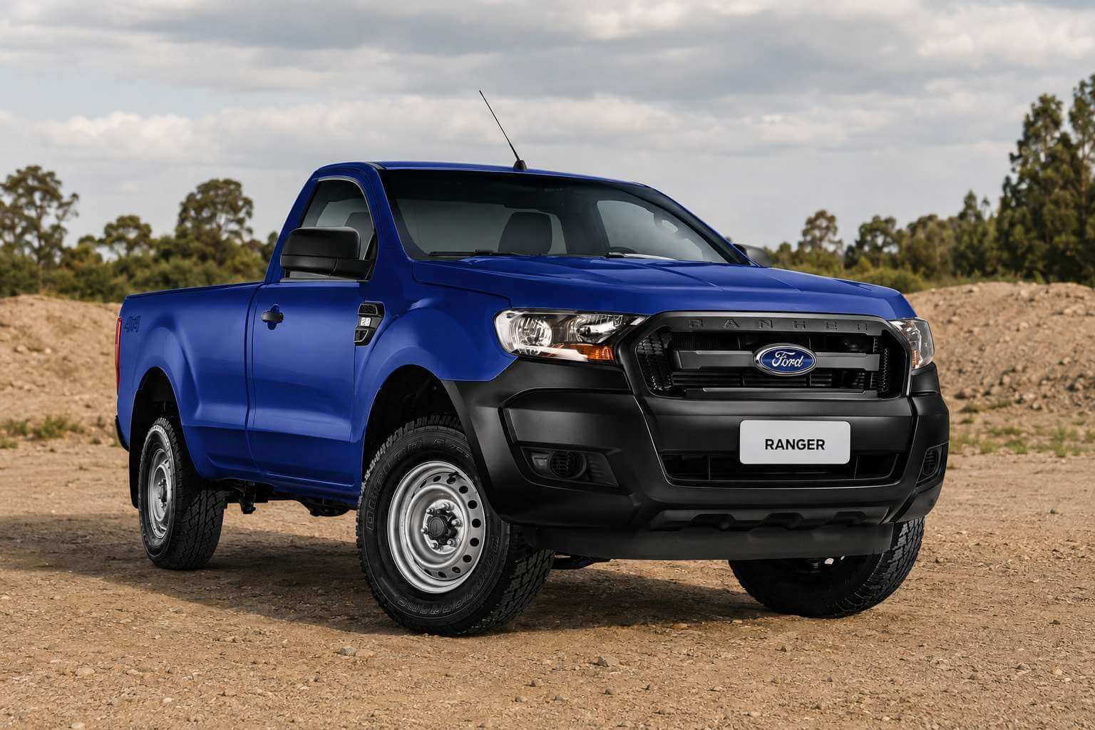 Ford Ranger XL 2.2 4x4 cabine simples 2019 na cor azul, vista em tres quartos dianteira, parada sobre um patio de terra batida e cascalho com um monte de terra e arvores ao fundo, sob luz natural de dia nublado. A picape tem cabine simples com cacamba, rodas de aco prateadas, para-choque e para-lamas dianteiros pretos, antena no teto, emblema Ford e a inscricao RANGER em relevo na grade, badge 4x4 na lateral da cacamba; a placa dianteira traz apenas a palavra RANGER.